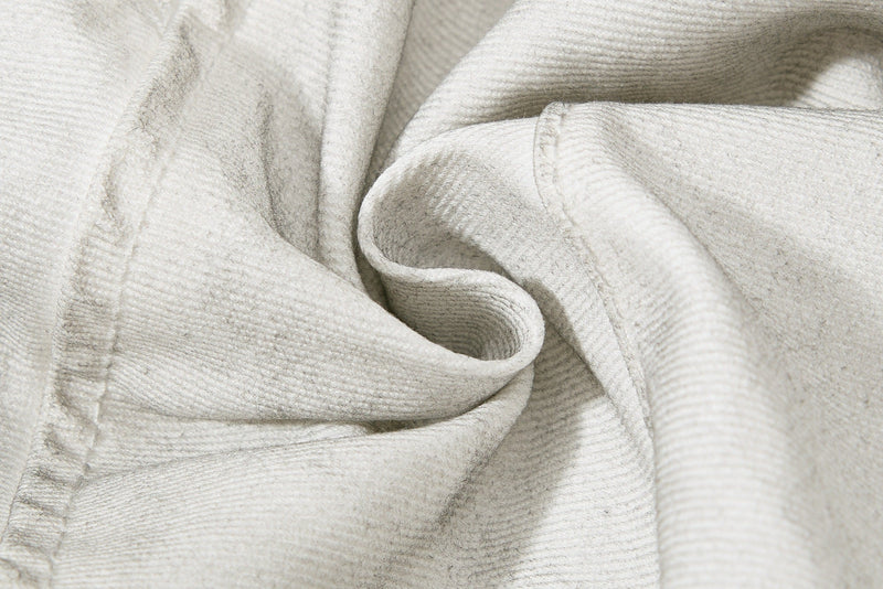Close-up of soft wrinkled denim fabric on light gray moto panel shorts