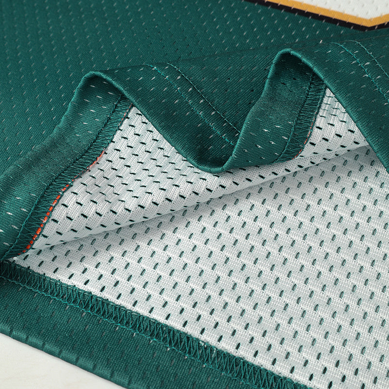 Close-up of a green vintage club football jersey with mesh lining and stitched hem detail
