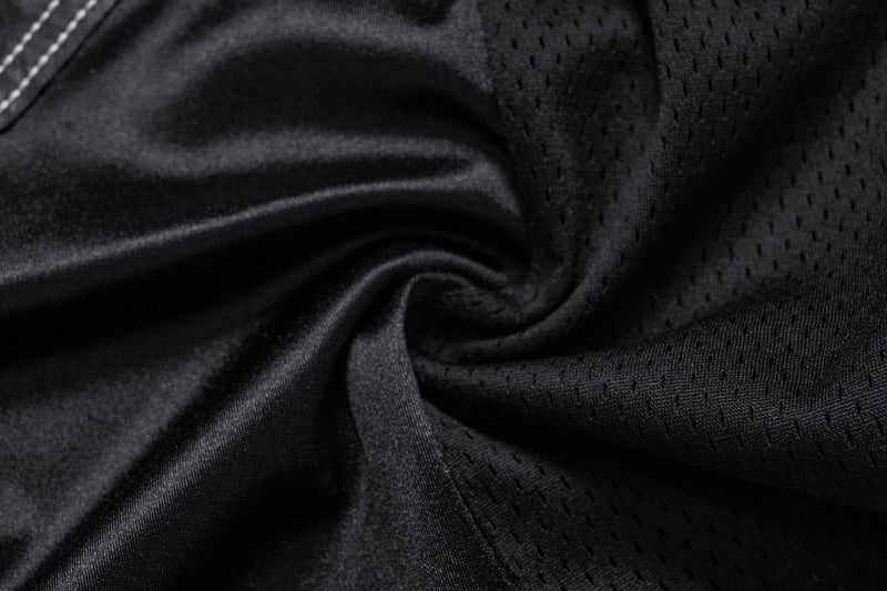 Close-up of black mesh fabric with smooth satin jersey panel