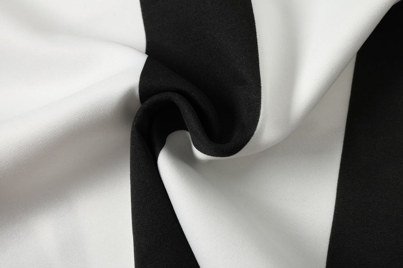 Black and white striped jersey fabric with a soft, draped texture and sporty football shirt styling