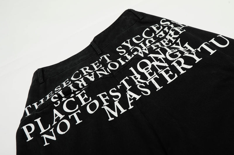 Close-up of white typography print on black cargo pants near the back waistband