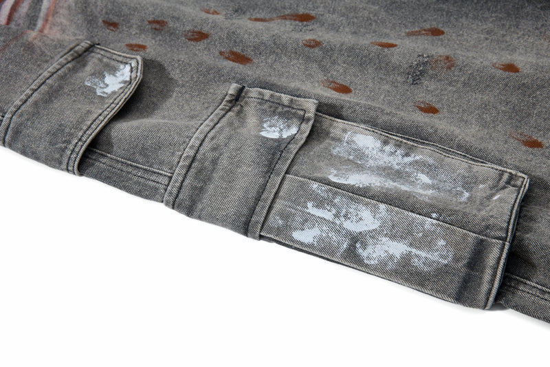 Close-up of a cargo pocket flap on gray jeans with white paint marks and splatter