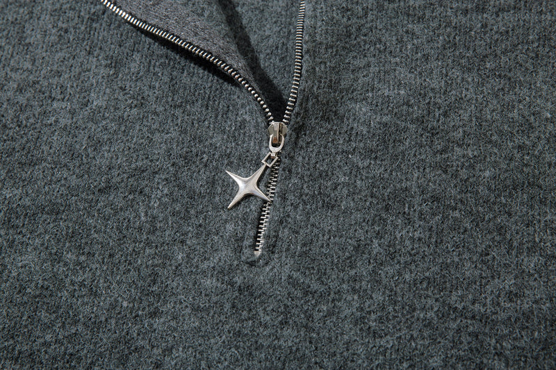 Close-up of half-zip front with star-shaped zipper pull on gray knit sweater