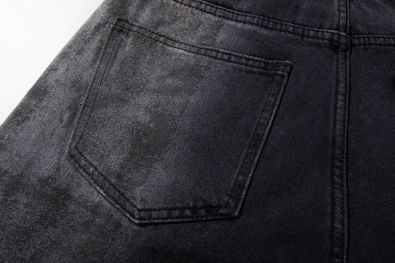 Close-up of back pocket on dark washed jeans showing faded smoky wash and stitched pocket shape