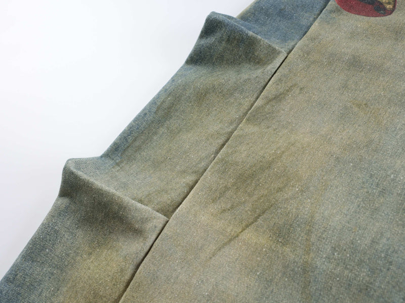 Close-up of plain blue denim fabric with soft folds and faded wash