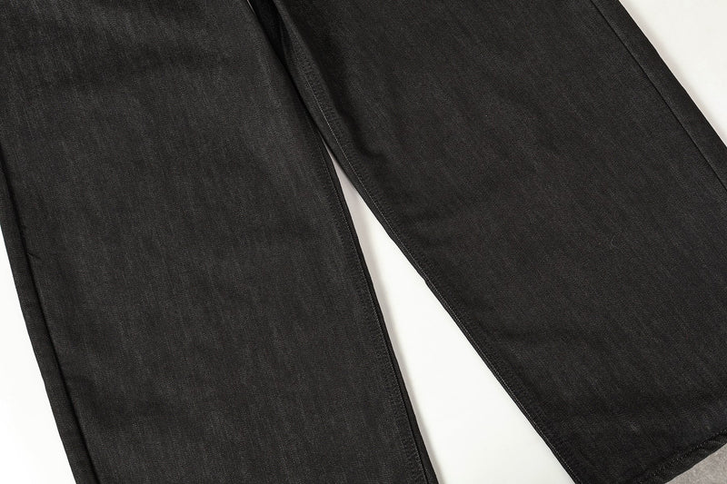 Black wide-leg jeans leg section laid flat, showing straight drape and smooth denim