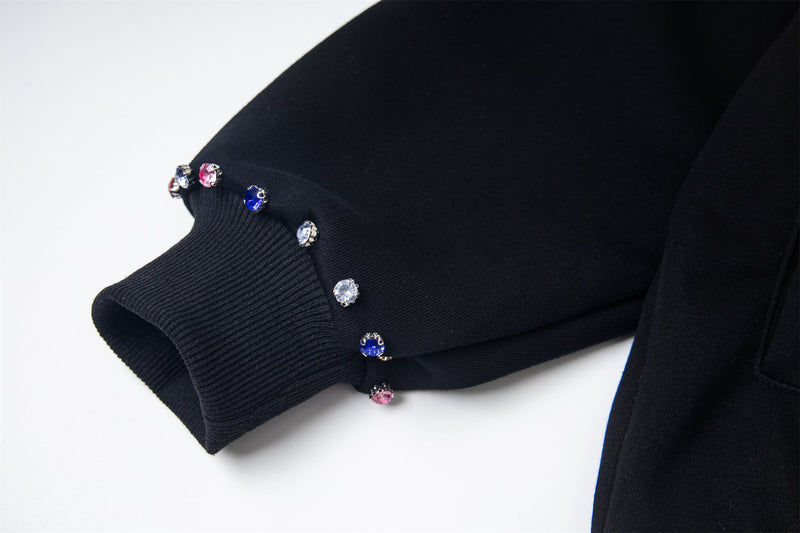 Close-up of black hoodie sleeve cuff with rhinestone studs