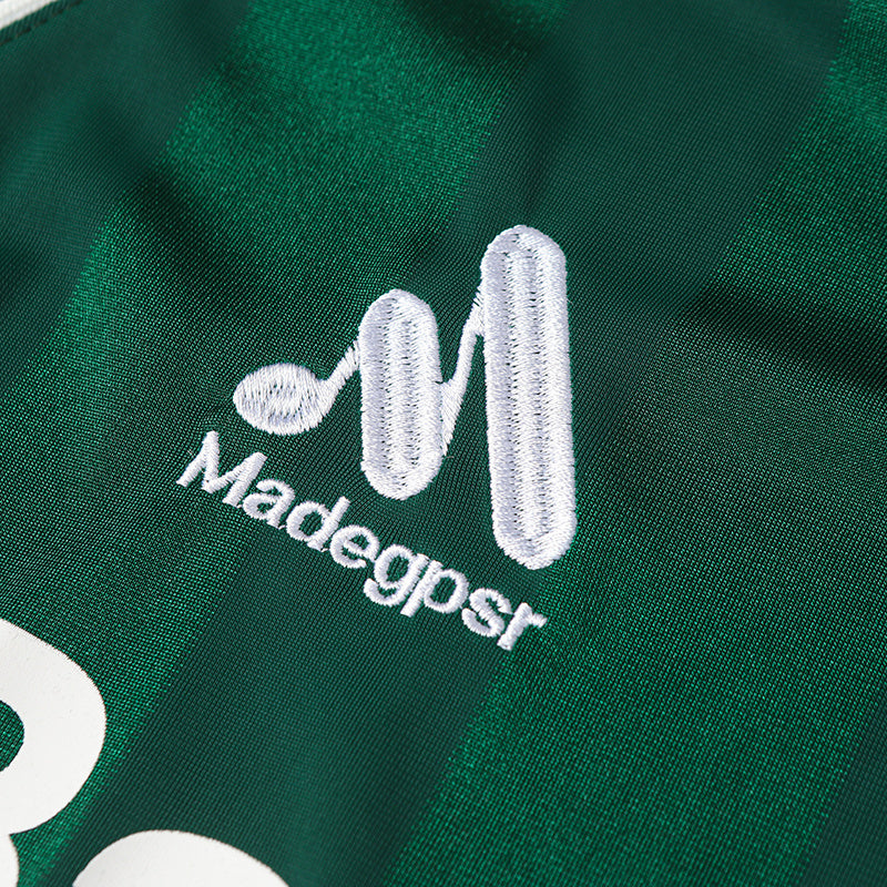 Green performance soccer jersey with embroidered white Madegpsi logo on breathable fabric