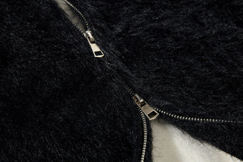 Close-up of black fuzzy hoodie with front zipper pull