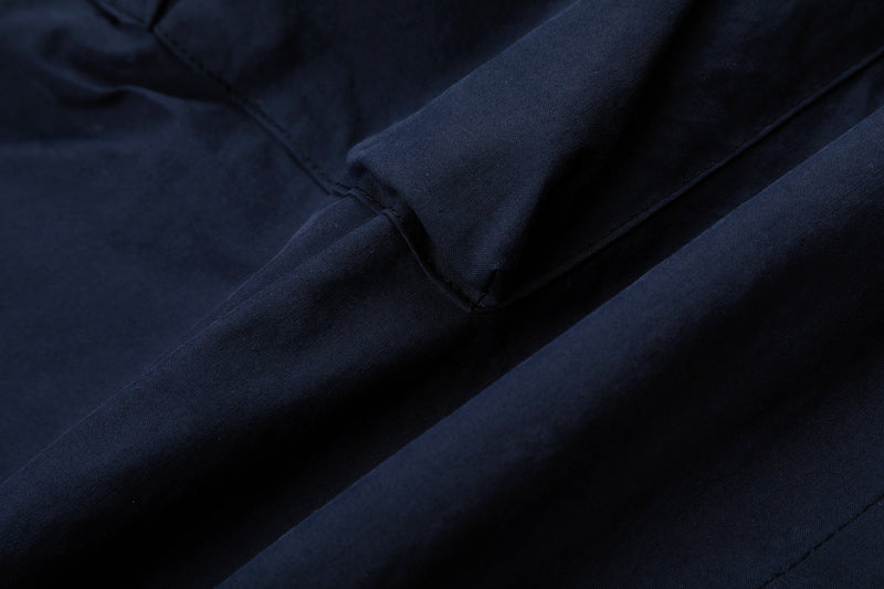 Close-up of navy cargo pants lower leg with seam lines and smooth fabric