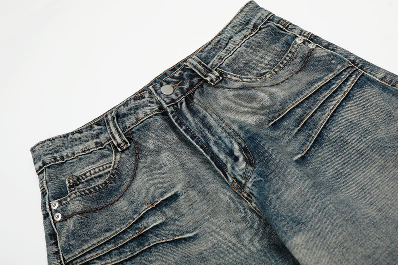 Close-up of the waistband and front pockets on faded blue wide-leg denim jeans