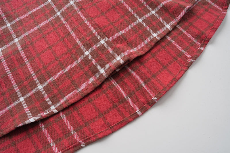 Red plaid flannel shirt side seam and curved hem close-up