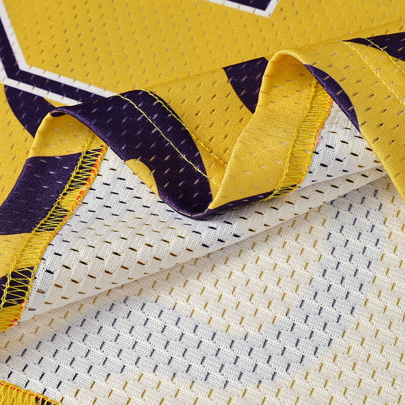 Close-up of a yellow and white football jersey with purple swirl accents and stitched mesh fabric details