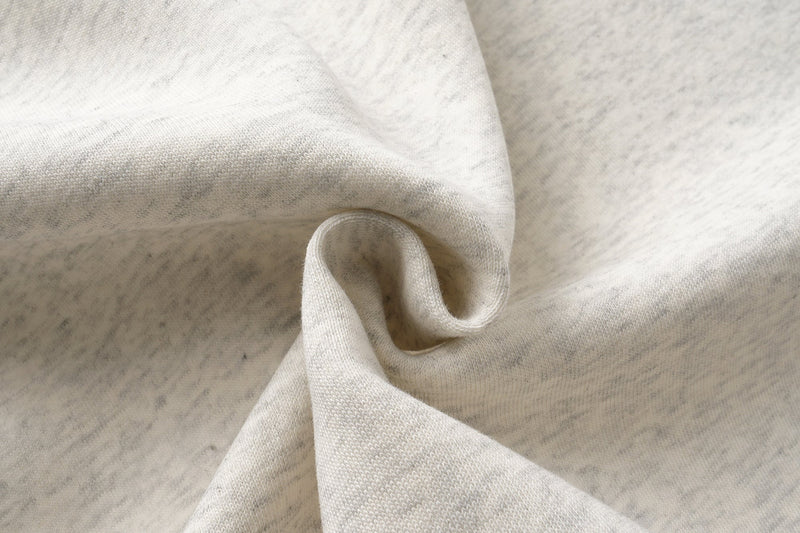 Close-up of gathered hoodie fabric and seam detail on heather gray material