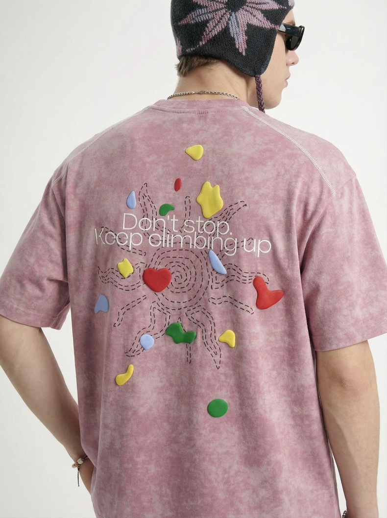 Back view of a pink vintage wash graphic tee with colorful climbing-inspired print and Keep climbing up text