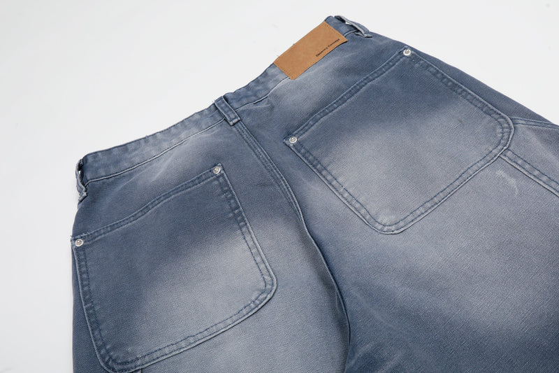 Close-up of back waistband and patch pockets on blue wide-leg denim jeans