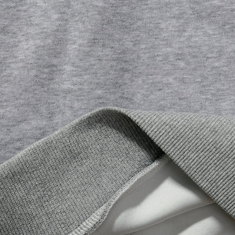 Gray hoodie fabric close-up with ribbed cuff and soft fleece lining