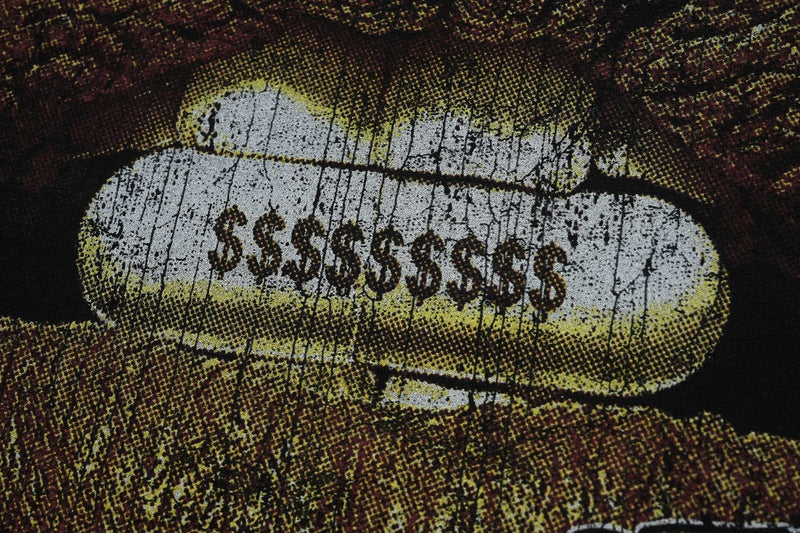 Close-up of a vintage washed graphic tee with distressed white pill print and dark streetwear styling