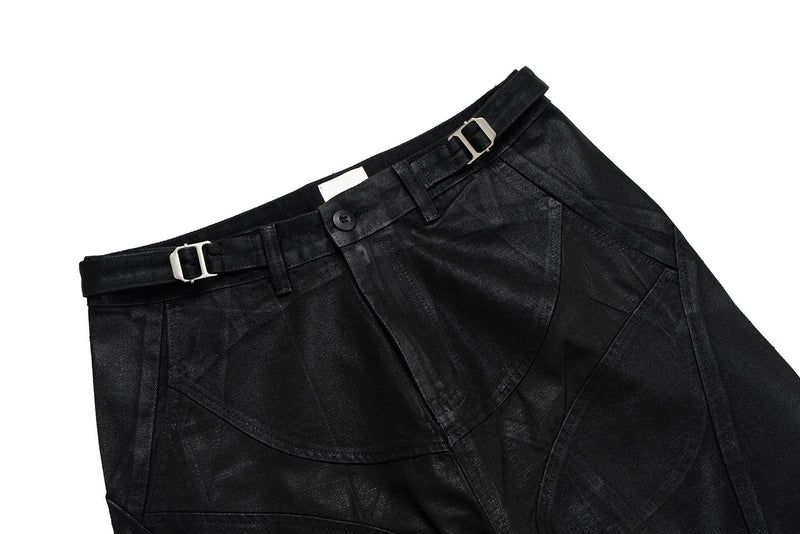 Black wide-leg pants laid flat, angled front waist view with belt and button closure