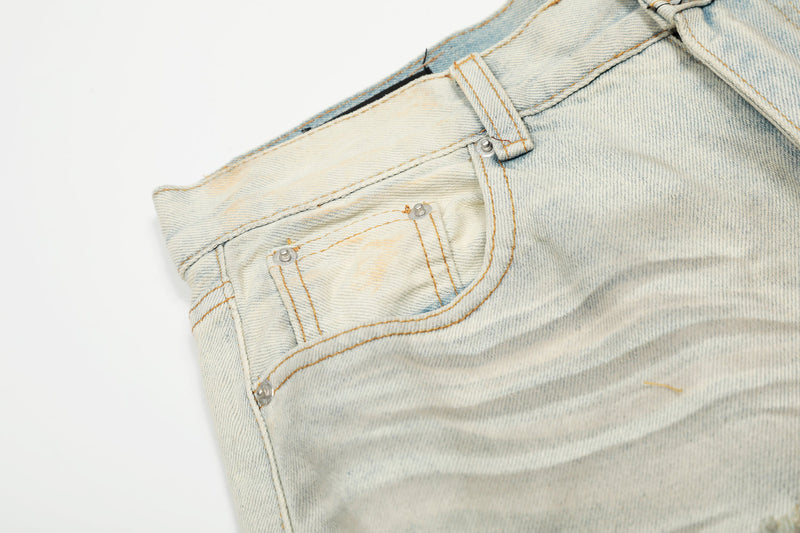 Close-up of front pocket and stitching on cream distressed denim