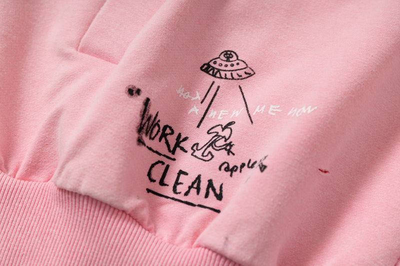 Close-up of pink hoodie front graphic and pocket area