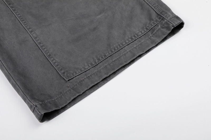 Close-up of gray cargo shorts hem showing double-stitched cuff and wide-leg finish