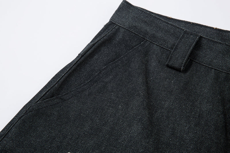 Angled close-up of the waistband and side seam on dark denim wide-leg pants