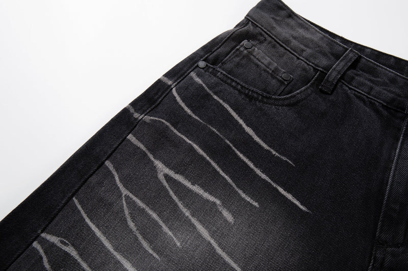 Side-waist close-up of washed black jeans showing scratch-fade detailing and front pocket seam
