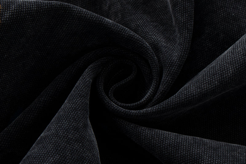 Close-up of black denim fabric texture folded in a swirl