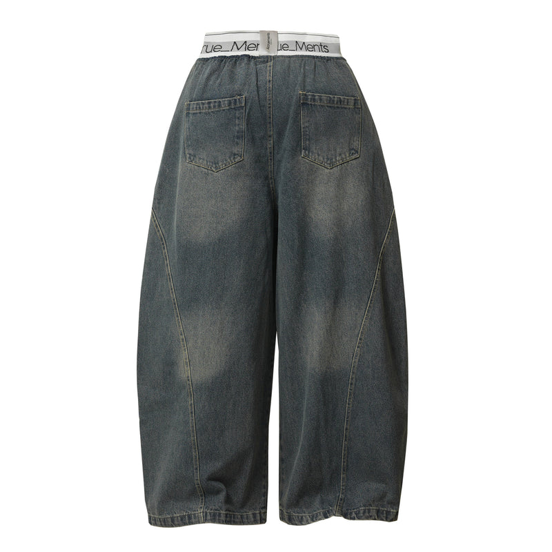 Back view of dark wash wide-leg denim pants with elastic waist and two patch pockets