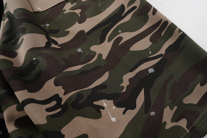 Close-up of camo patchwork fabric with white paint splatter detail