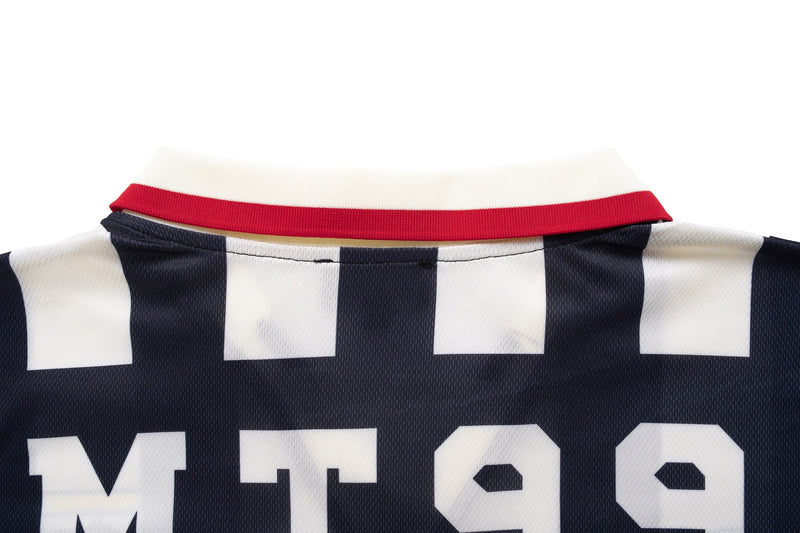Close-up of a navy and white striped varsity soccer jersey with a red collar and bold retro lettering