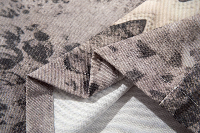Close-up of stitched cross patch on washed gray denim shorts