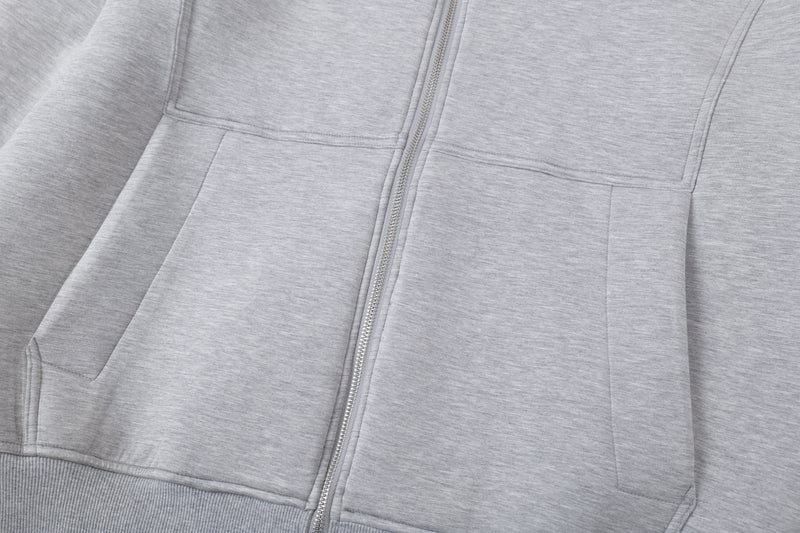 Close-up of front chest panels and zipper on light gray zip-up hoodie