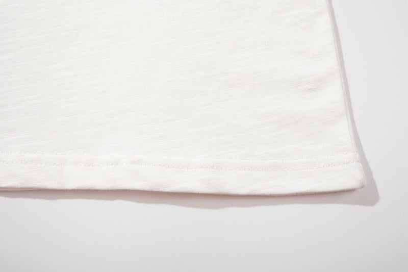 Close-up of a white Number (N)ine graphic T-shirt hem with subtle stitched detailing on soft cotton fabric