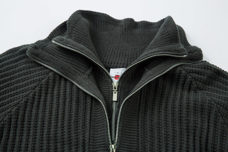 Close-up of black ribbed knit sweater collar and zipper with interior label visible