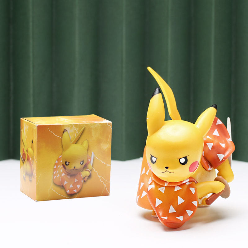 A delightful Demon Slayer Pikachu figurine from the 4-piece set is styled in an orange Halloween pumpkin costume with triangular patterns. Displayed beside its matching box, a green backdrop enhances the festive feel, making it an excellent addition to any anime collection.