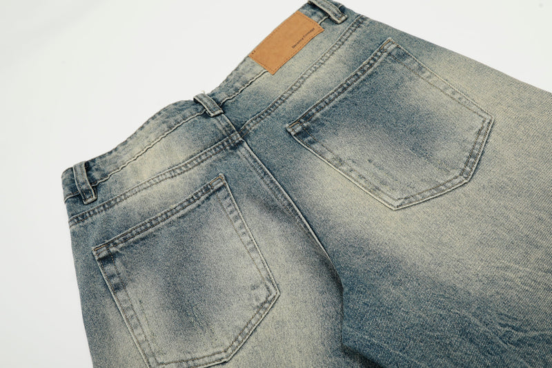 Back view close-up of jeans pockets and tan patch label on faded blue denim