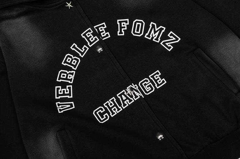 Close-up of arched white Verblee Fomz Change print and front snap buttons on black jacket