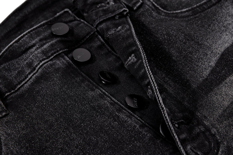 Close-up of front button fly on black washed denim jeans
