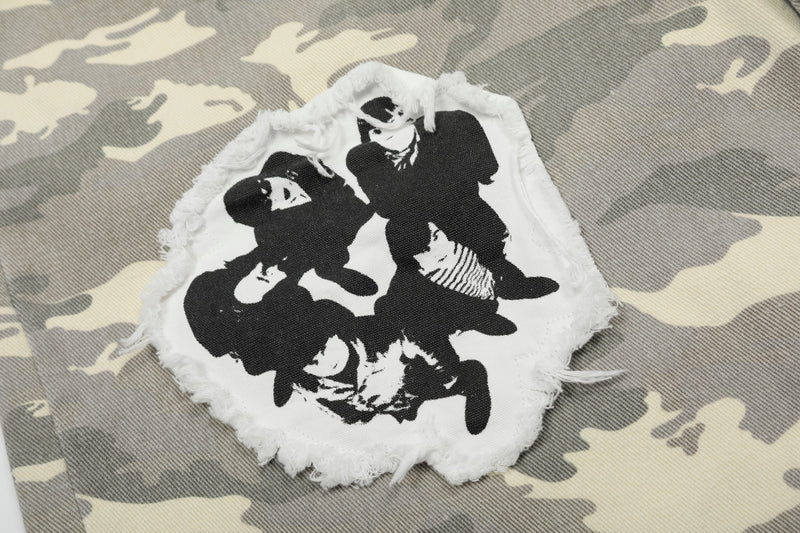 Close-up of black-and-white graphic patch sewn onto gray camo shorts