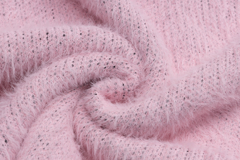Close-up of pink fuzzy knit sweater fabric texture and loose knit folds