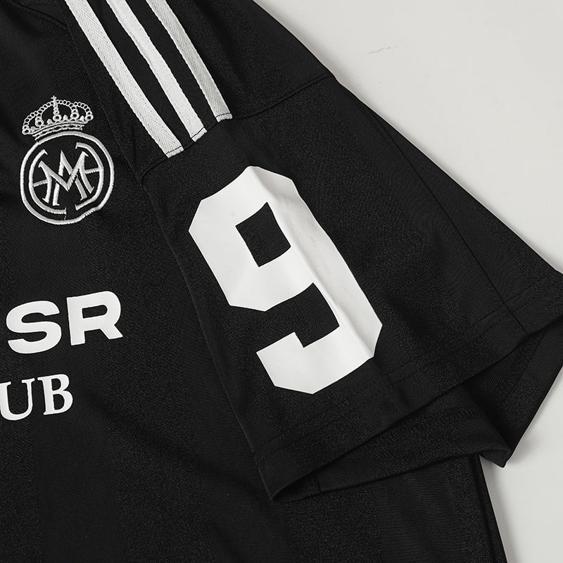 Black MADEGPSR sports club football jersey with white stripes, crest logo, and large number 9 on the sleeve