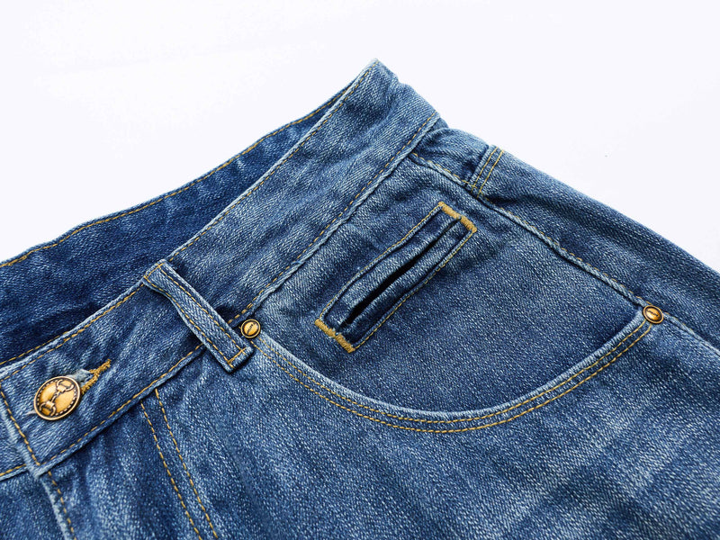 Close-up of a back pocket and upper waistband on blue denim shorts with a small welt pocket
