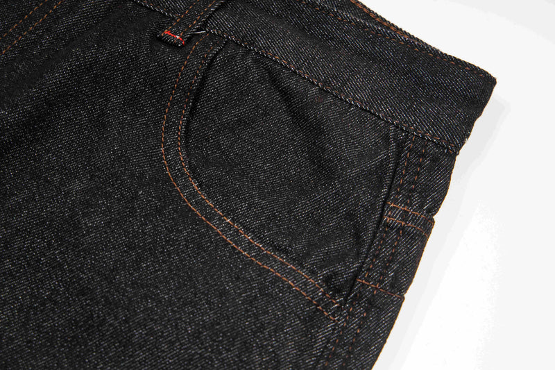 Close-up of dark wash denim side seam and front pocket opening