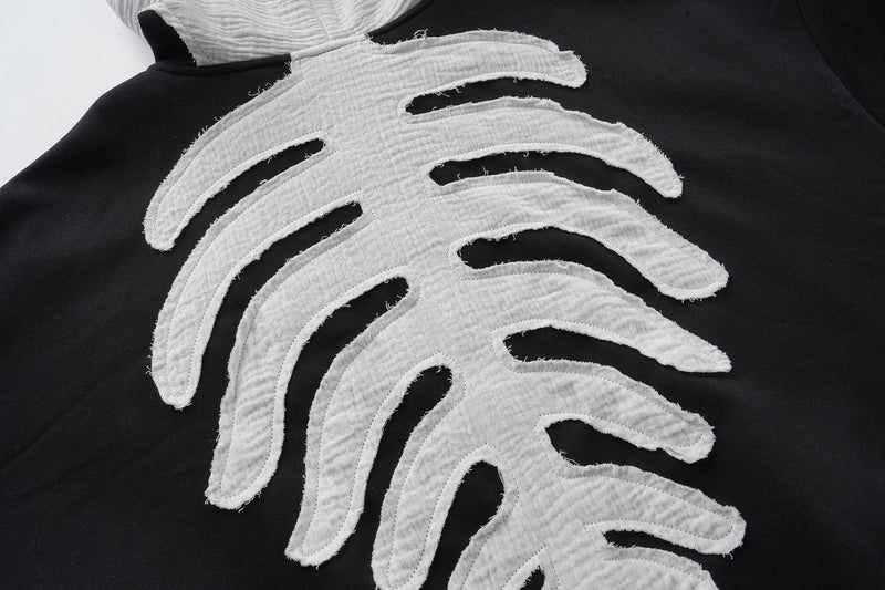 Back graphic close-up of white skeleton ribs on black hoodie