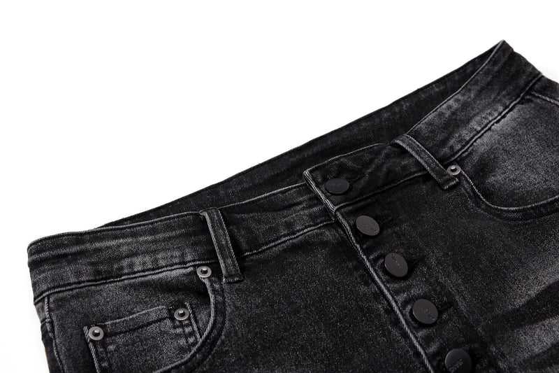 Close-up of black washed denim waistband with belt loops, front button fly and pocket