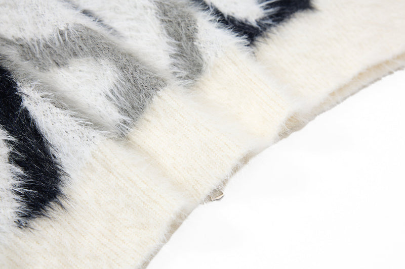 Close-up of cream ribbed cuff on black and white faux-fur hoodie sleeve