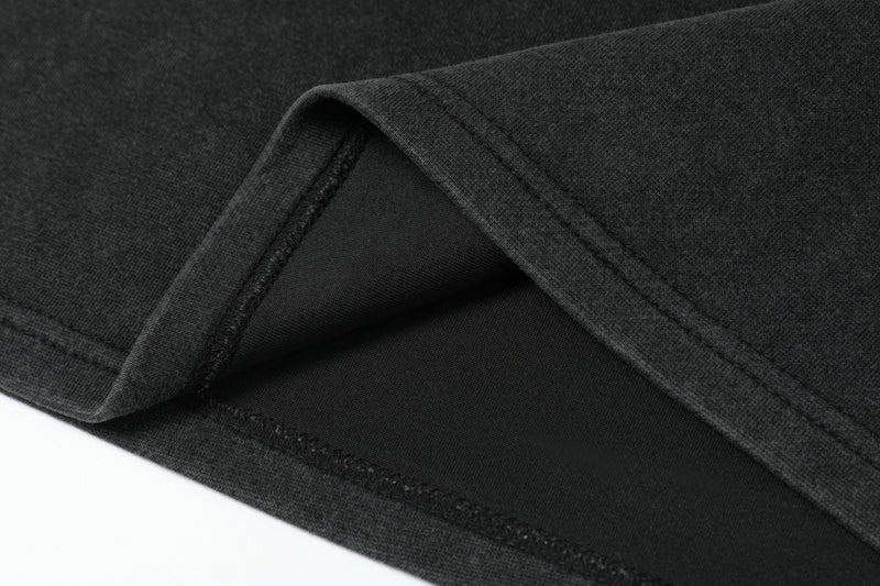 Close-up of black sleeve hem and seam stitching on layered long sleeve tee