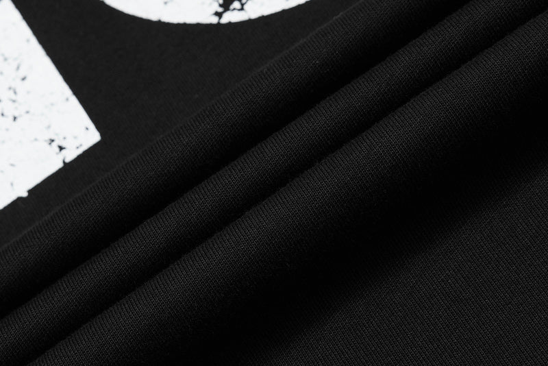 Close-up of black textured streetwear polo tee fabric with bold graphic print detail